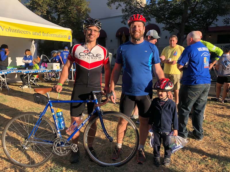 Two adults and a child participating in the Sacramento Century Challenge cycling event.
